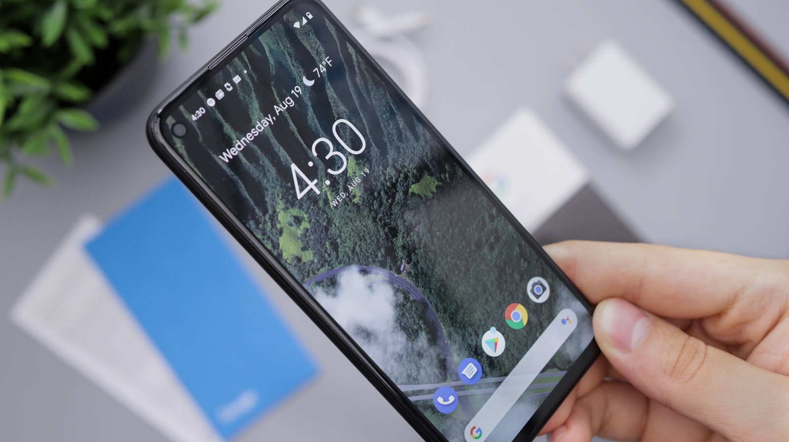 Android phone held in one hand showing the home screen